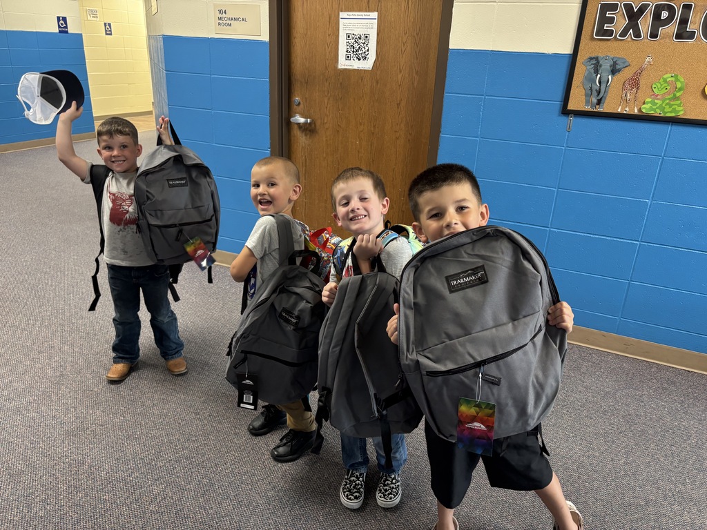 4 boys smiling with their new backpacks