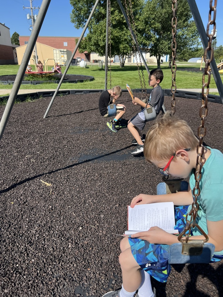 3 boys on a swing reading