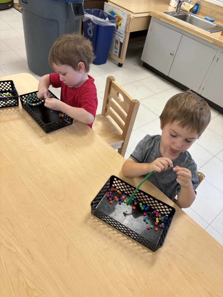 Using our fine motor skills to thread beads onto a pipe cleaner!