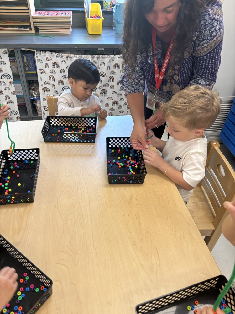 Using our fine motor skills to thread beads onto a pipe cleaner!
