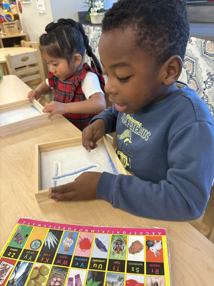 Working on our fine motor skills and learning to form letters in the sand.