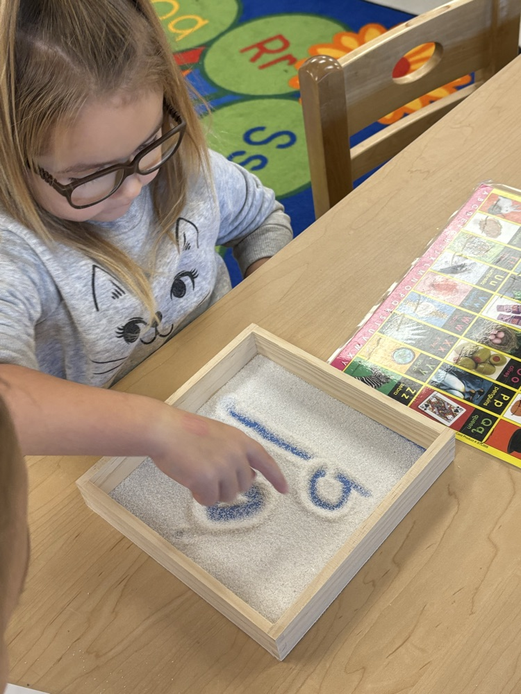 Working on our fine motor skills and learning to form letters in the sand.