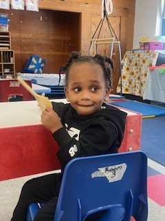 Pre K student sitting on a chair.