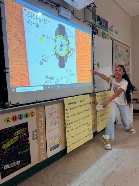 student smiling and pointing to the board