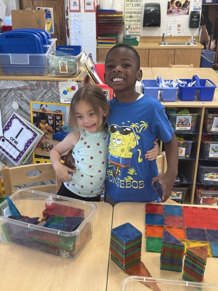 two children building with magnatiles 
