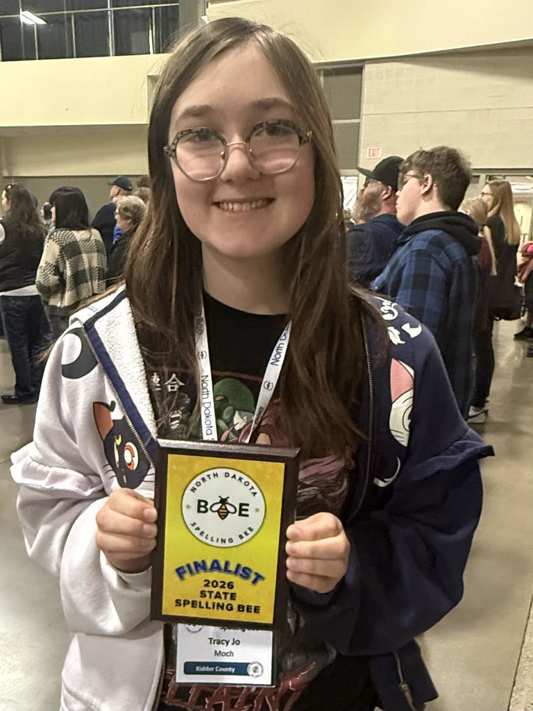 Moch holding a finalist plague from the state spelling bee in 2026.