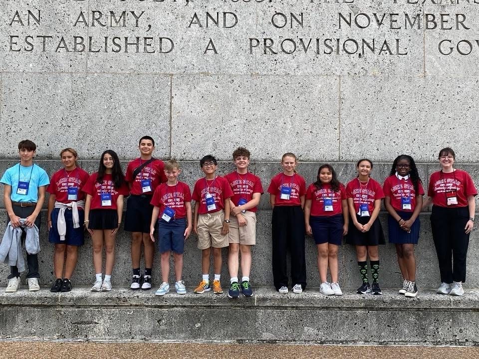 a row of students lined up smiling at the camera for the lodestar leadership academy