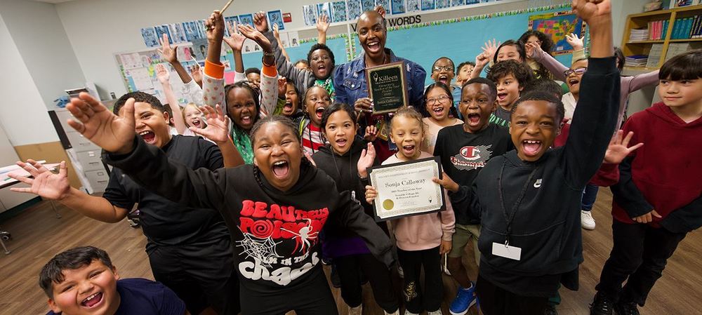 Group photo of happy students with their award-winning teacher