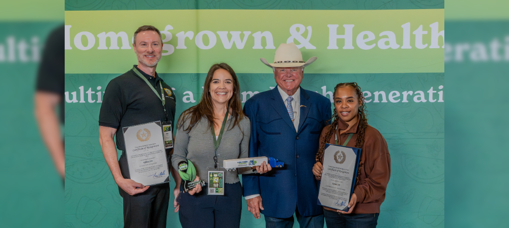 a group of men and women standing next to each other holding awards and plaques smiling at the camera