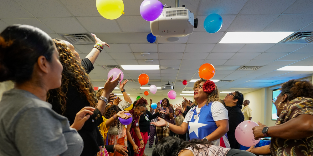 people pushing balloons in the air laughing and smiling
