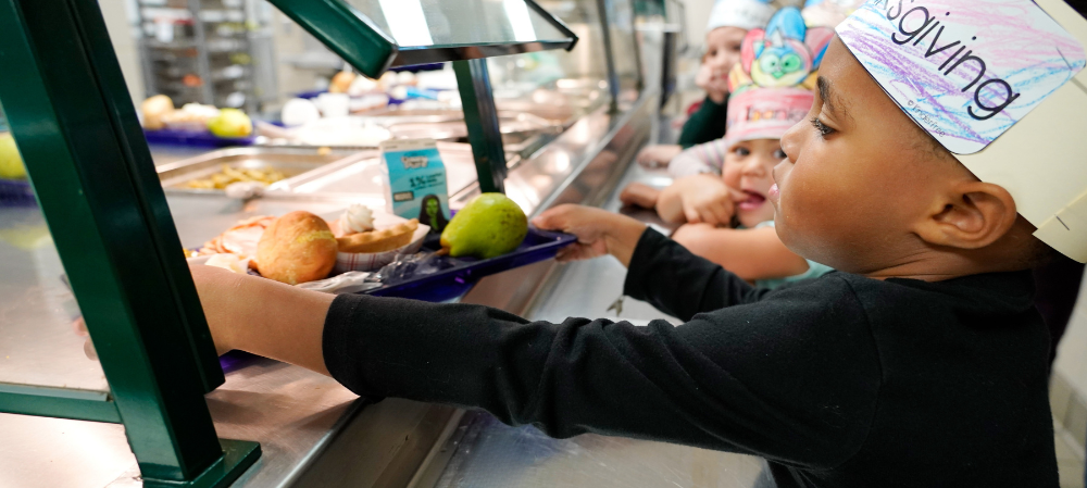 Kids grabbing a tray from the kitchen lunch line