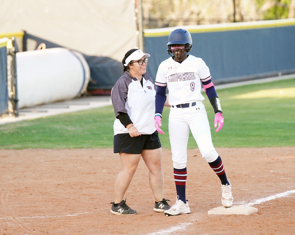 Coach and softball player at third