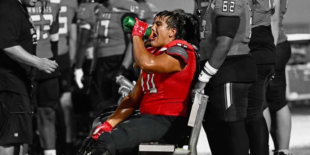 image of student drinking water at a football game