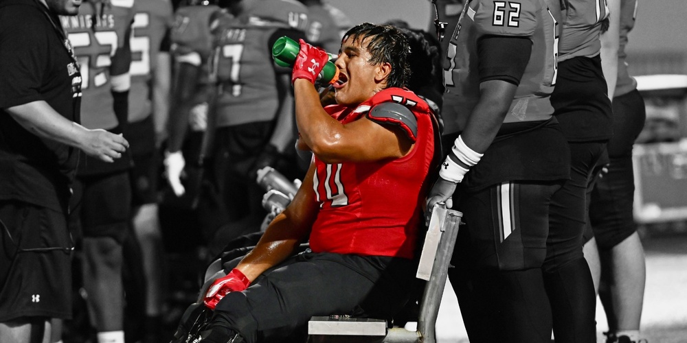 image of student drinking water at a football game