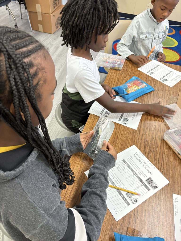 student touching wax paper and foil 