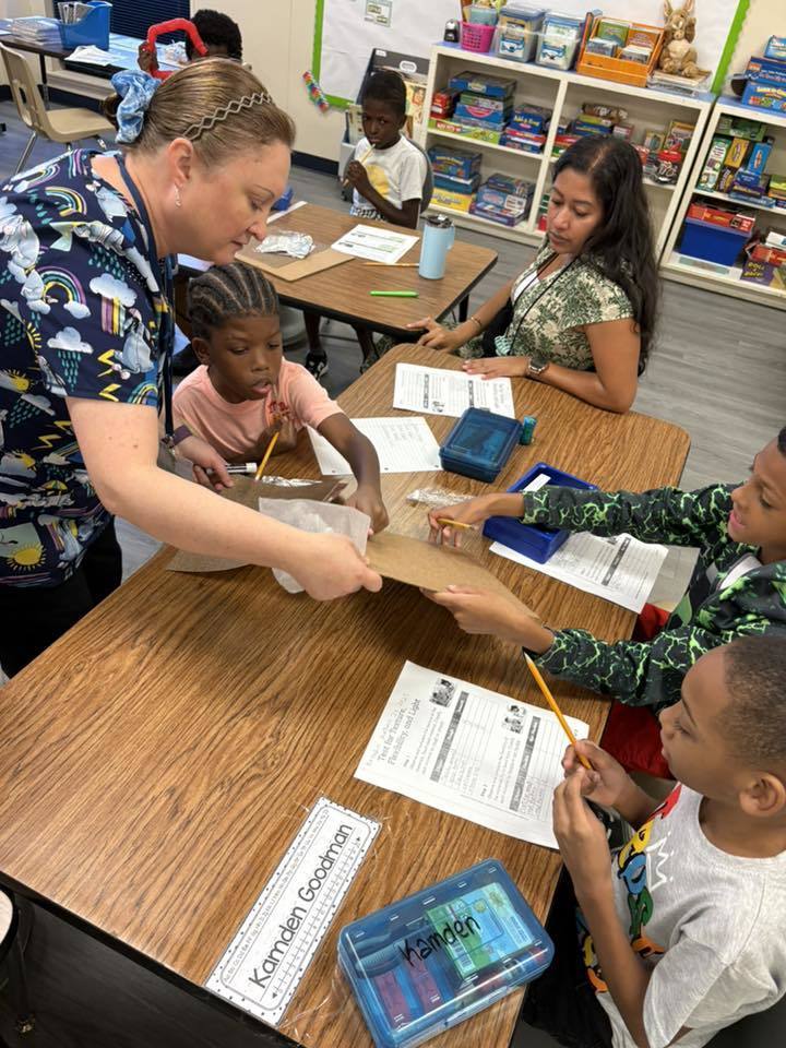 teacher guiding student to touch cardboard