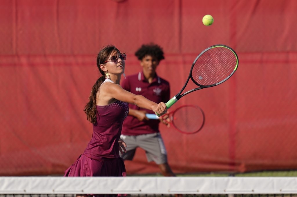 KHS tennis player reaches for the ball