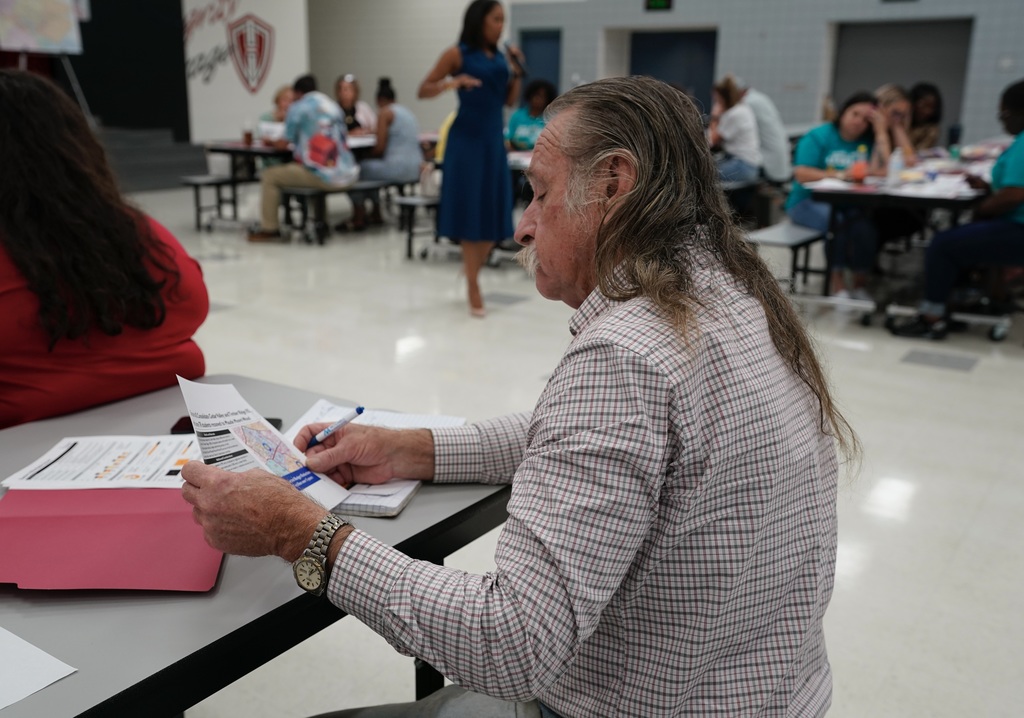 man looking a proposed scenarios for district optimization