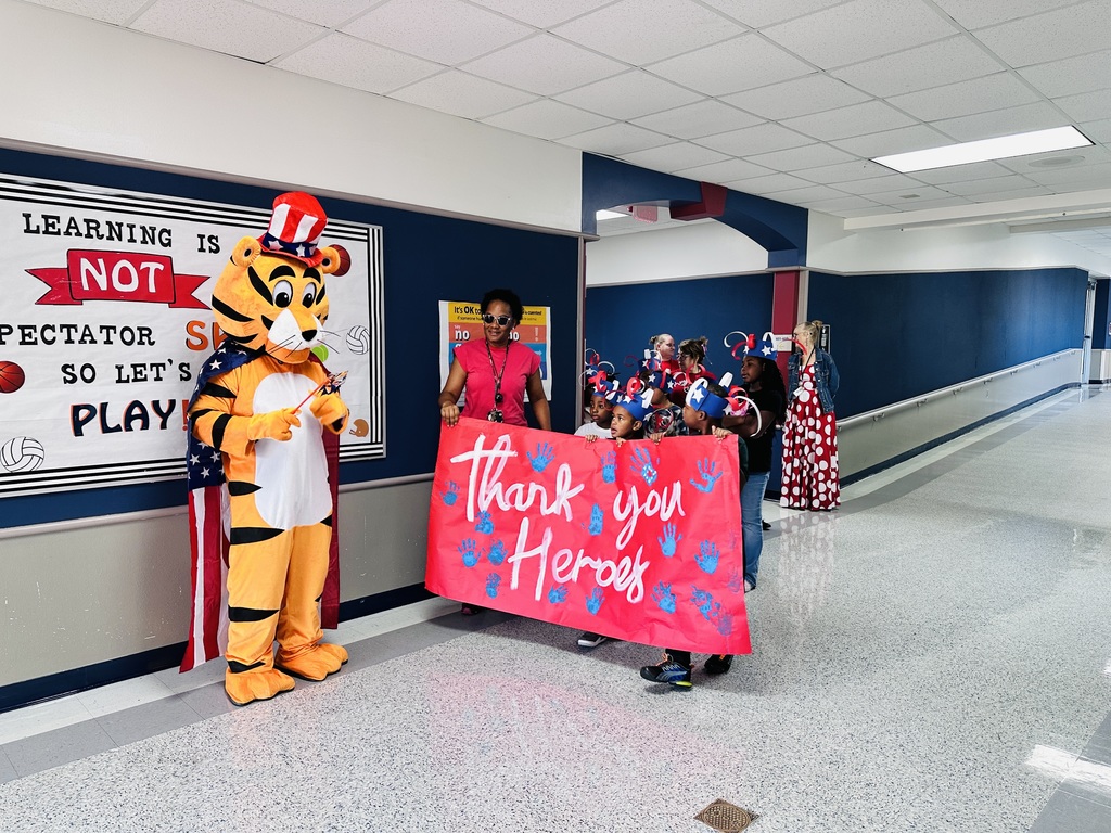 Tiger mascot with students holding a banner