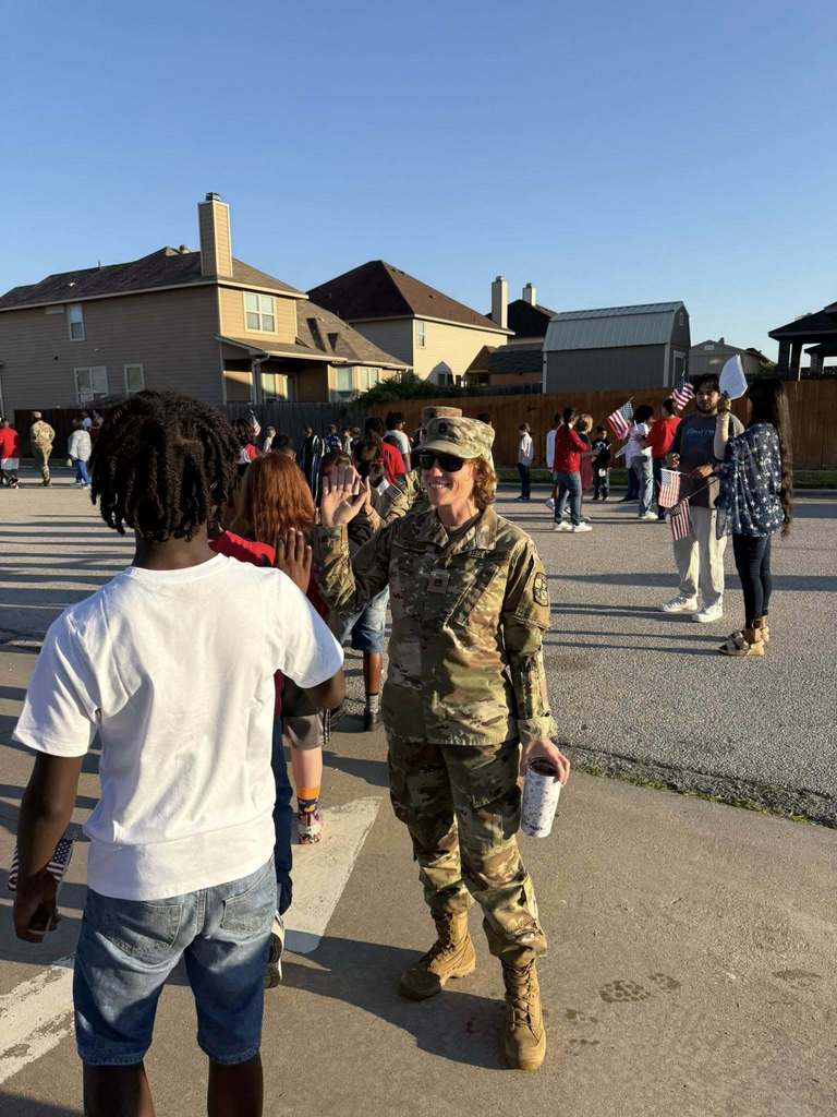 soldier high five student