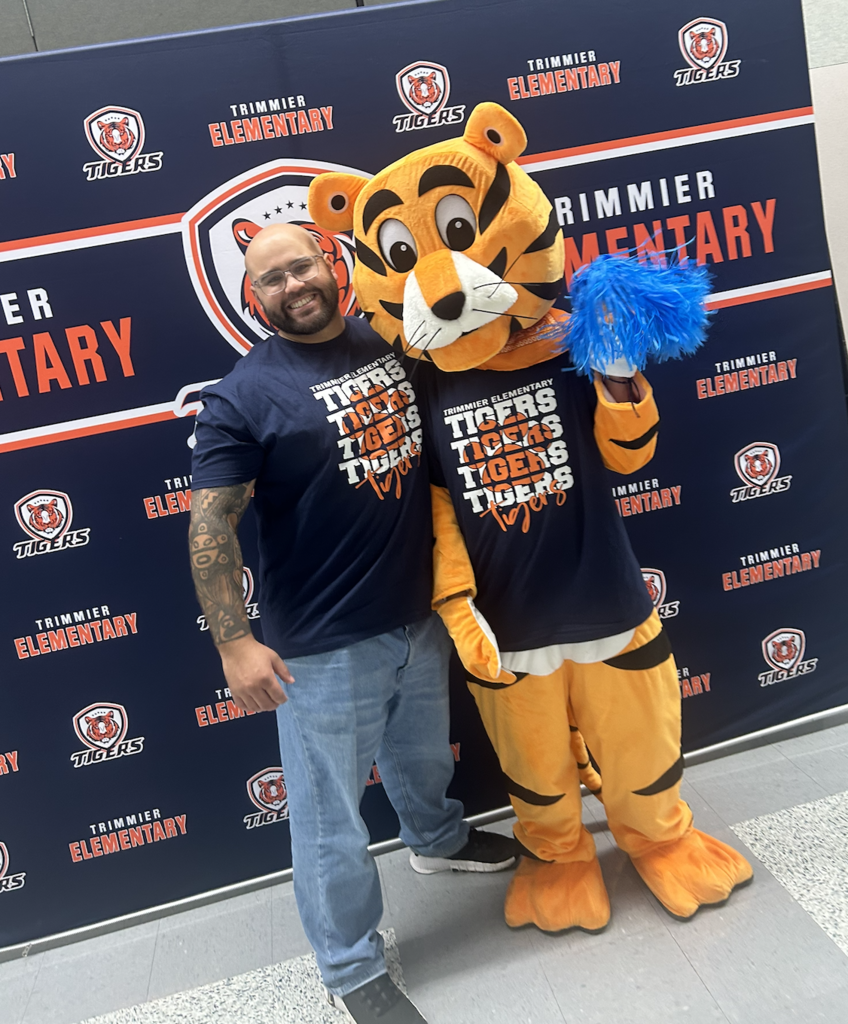 A man and Tiger Mascot posing for a picture