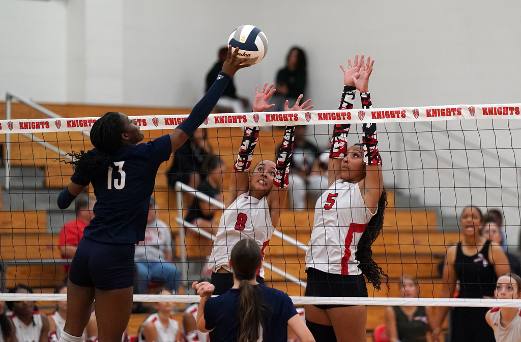 HHHS volleyball players block a shot