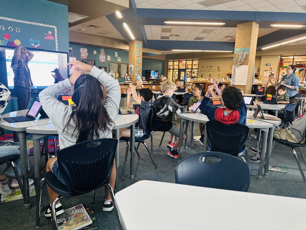 photo of students with their hands up in a T shape