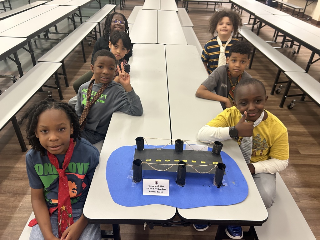 A group of students with a paper bridge