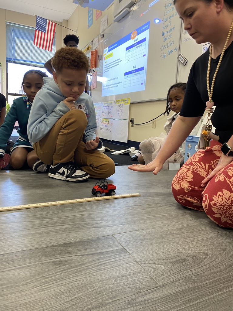 student and teacher rolling car for experiment