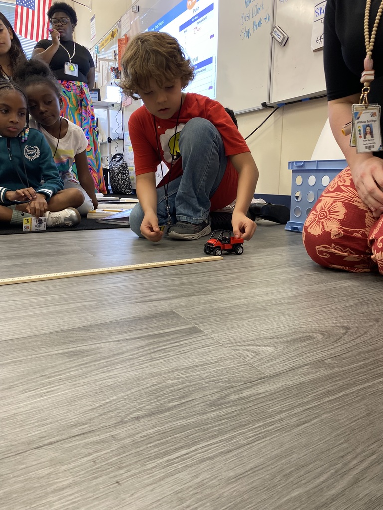 student and teacher rolling car for experiment