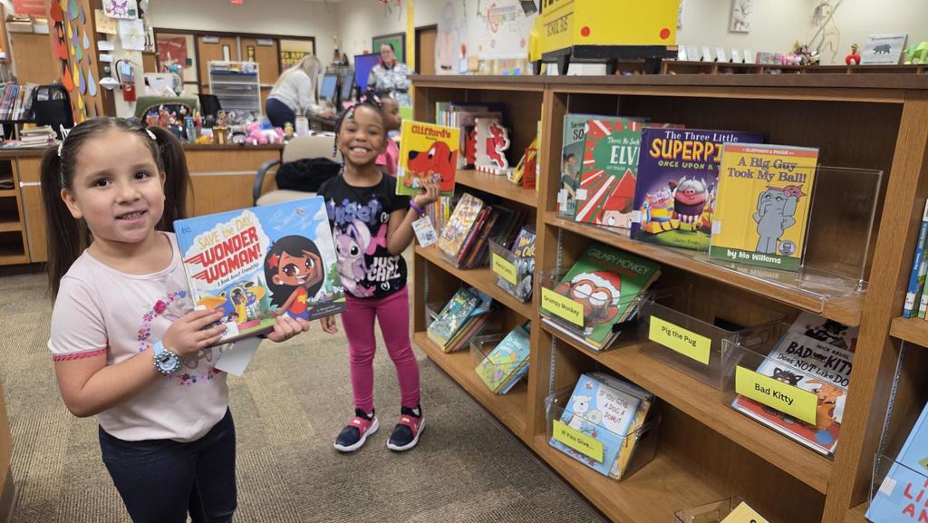 kids looking at books on a shelf