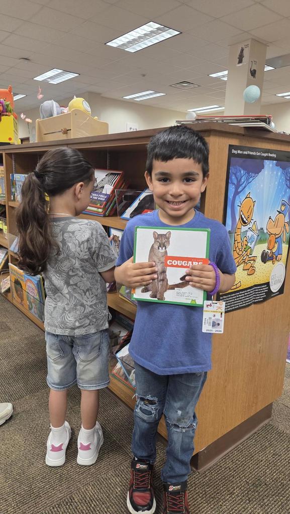kids looking at books on a shelf