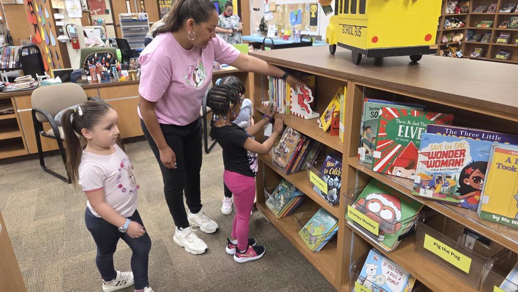 Kids looking at books on a shelf