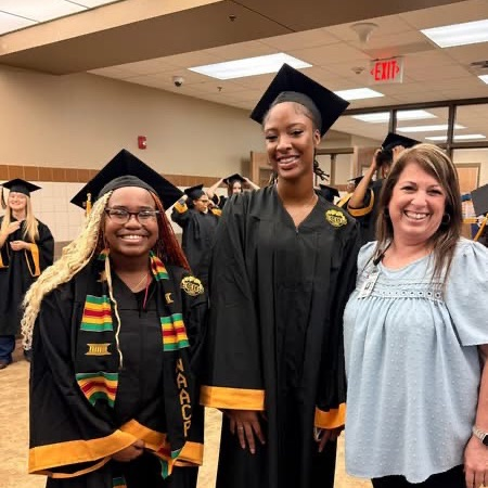 students with cap and gown with Mrs Hardy Principal