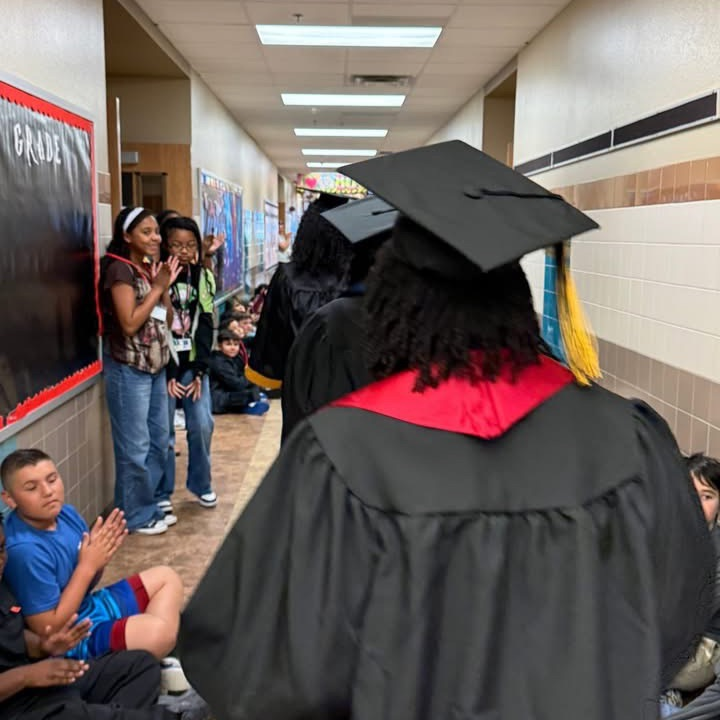 students in cap and gown walking the hall