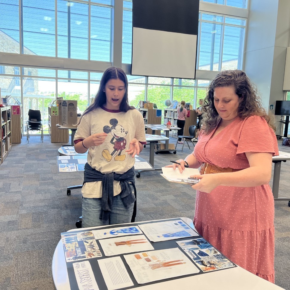 Students explain their designs to judges