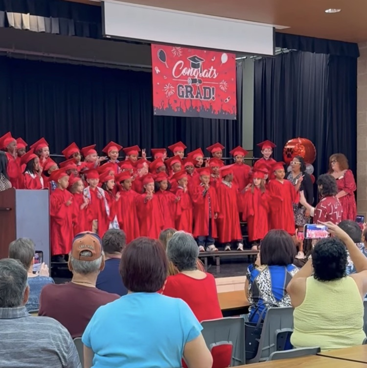 kinder graduates singing on stage