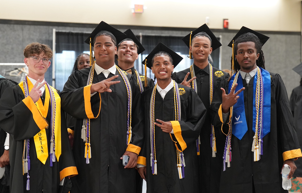 group of boys smiling throwing up peace sign