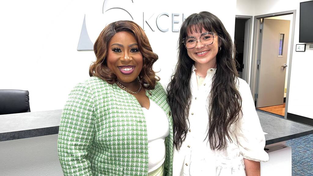 two women standing next to each other smiling at camera 