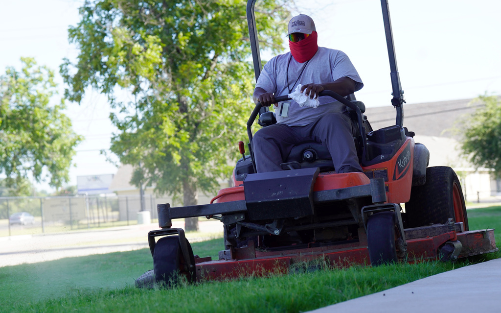 KISD employee mows the lawn