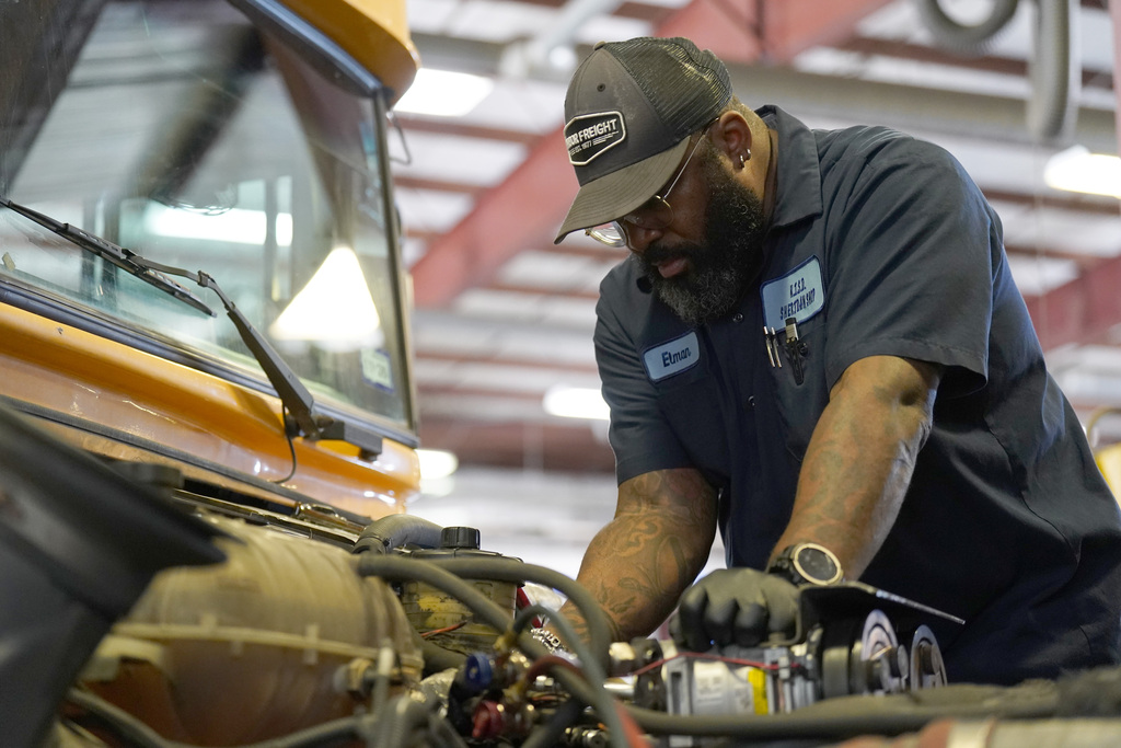 KISD employee works on a bus engine