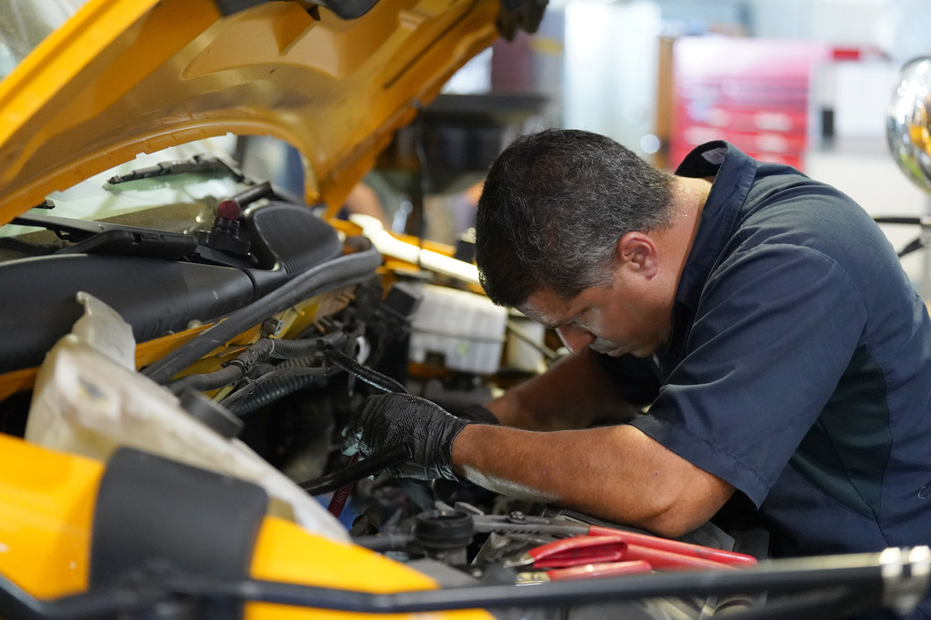 KISD employee works on a bus engine