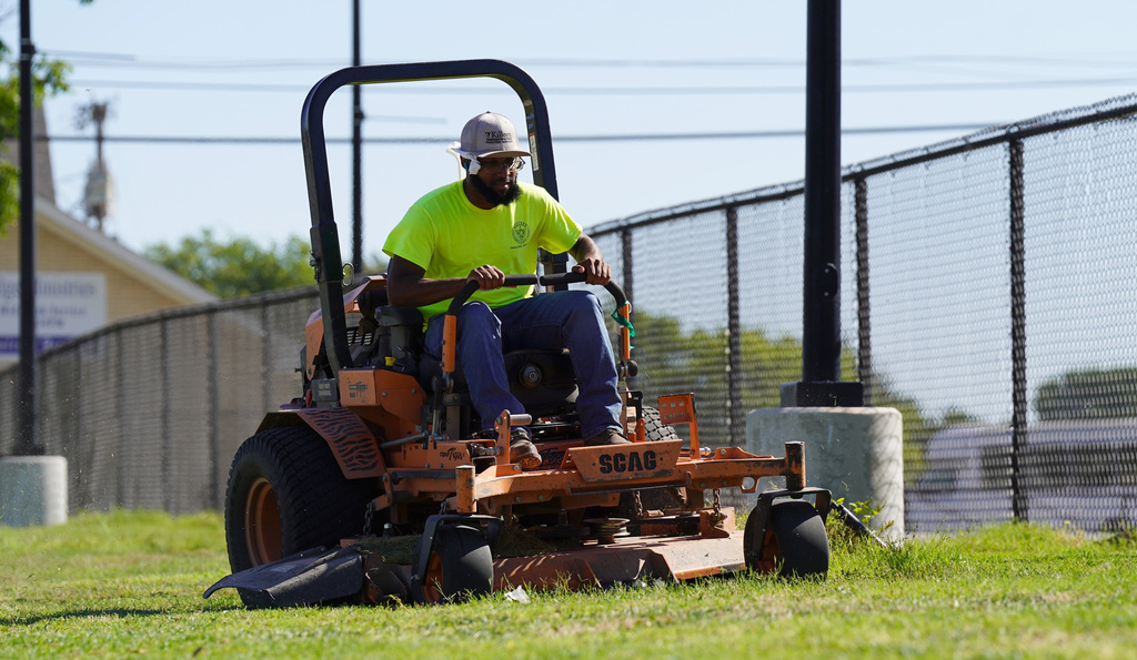 KISD employee mows the lawn