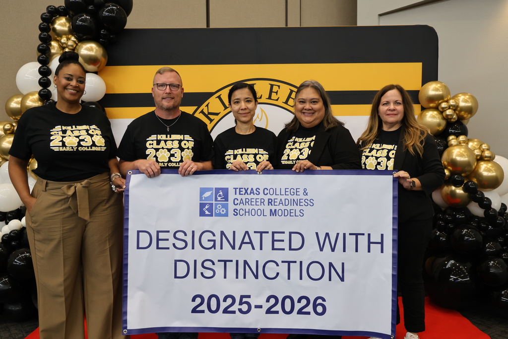 group photo of people smiling holding up banner looking into camera