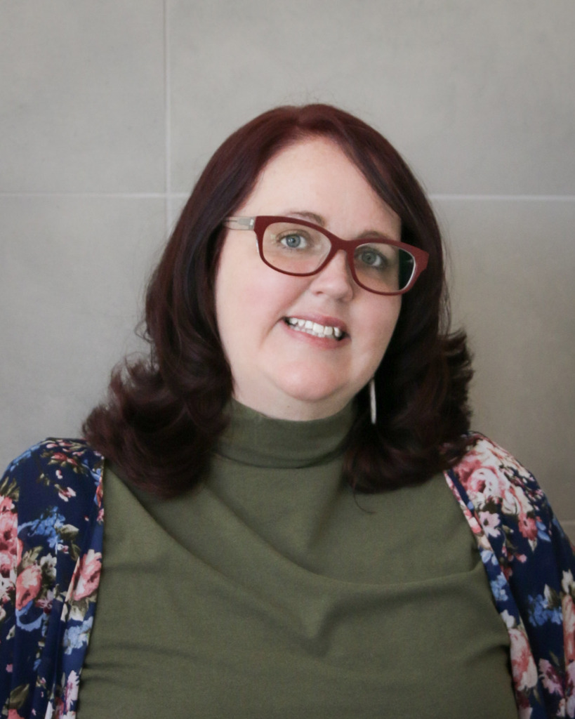 woman wearing glasses smiling at camera