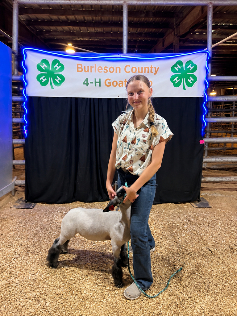 student holding goat at FFA showing smiling at camera