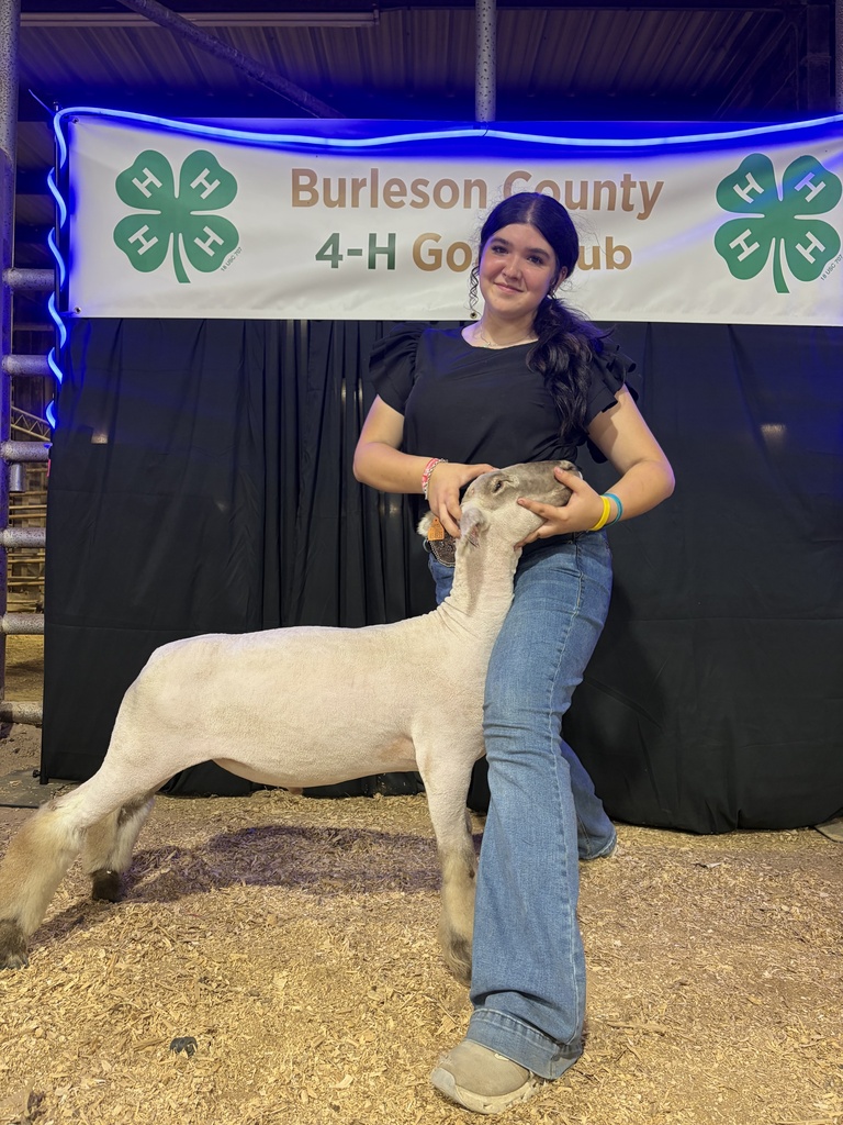student holding goat at FFA showing smiling at camera