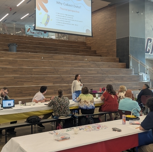 Teachers listen to presenter in a cafeteria 