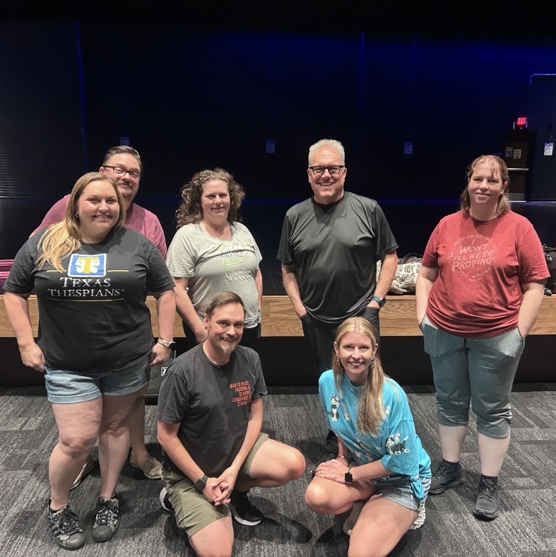 Seven teachers in front of a stage
