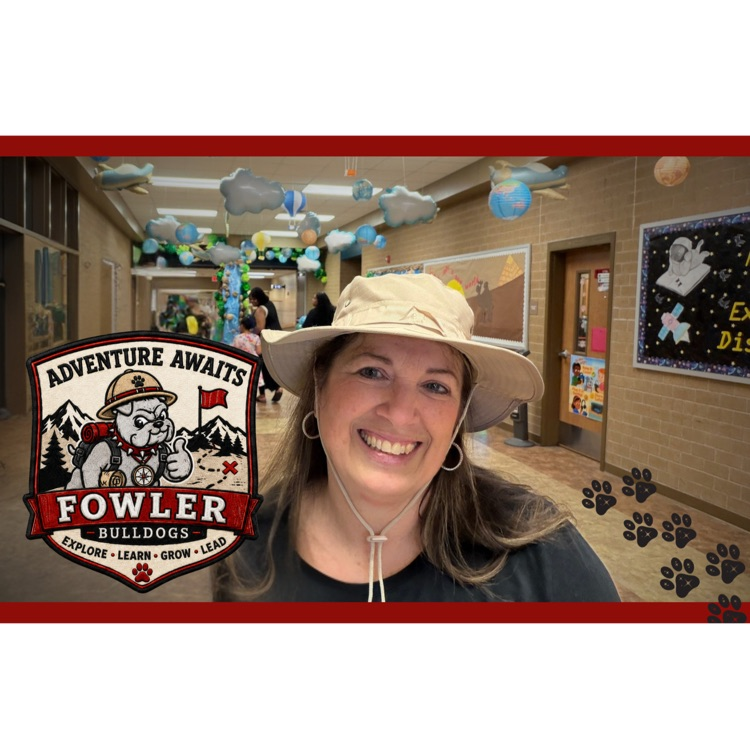 Dr Hardy principal of Fowler standing in the main hallway with blue balloons overhead.